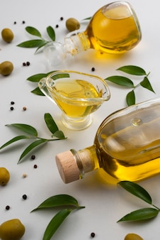 Натуральное оливковое масло на бутылке и чашка на столе