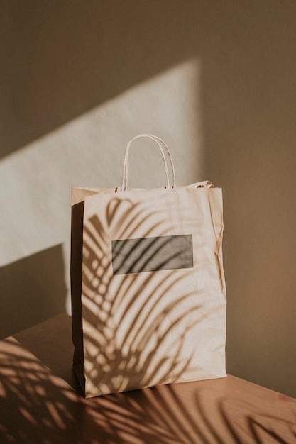 Free photo natural paper bag with palm leaves shadow