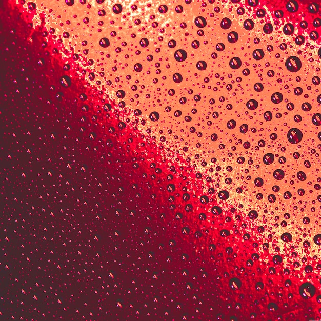 Natural pattern of water drops on red and an orange background