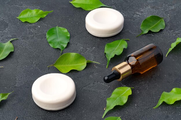 Natural soap and green leaves on dark gray background