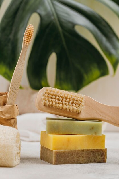 Natural wooden brushes and soaps blurred monstera leaf