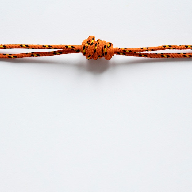 Free photo nautical orange rope knot with shadows