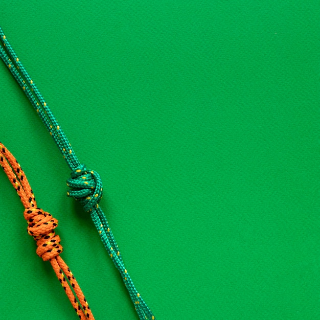 Nautical rope knots copy space green background