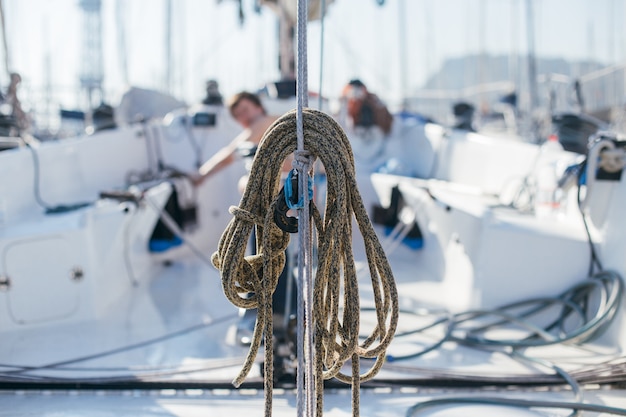Free photo nautical ropes, buntine, capstan and cablet piled up on deck of professional racing yacht or sailboat, attached to mast or forestay, different colors