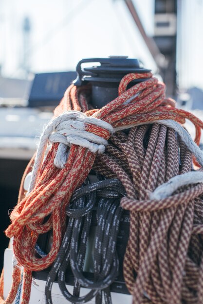 Nautical ropes, buntine, capstan and cablet piled up on deck of professional racing yacht or sailboat, attached to mast or forestay, different colors