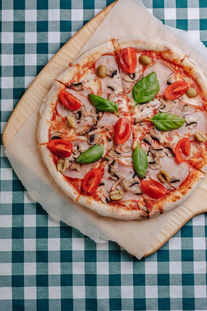 Neapolitan pizza with mushrooms, cheese, arugula, basil, tomatoes sprinkled with cheese