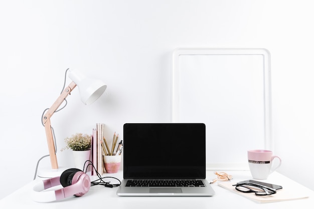 Neat workplace with laptop headphones and stationery