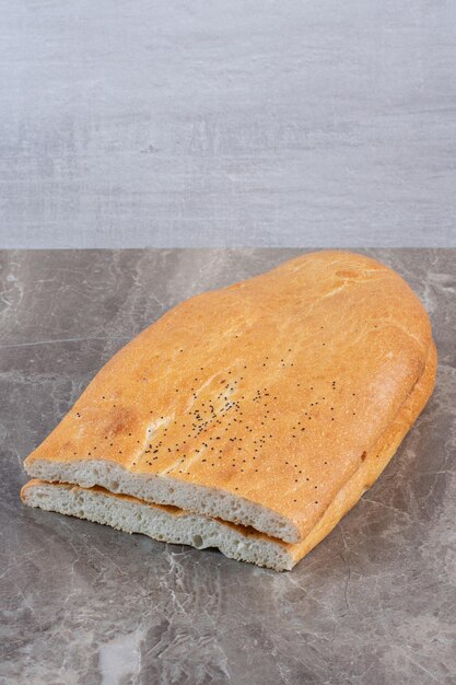 Neatly sliced half-loaf stack of tandoori bread on marble background. High quality photo