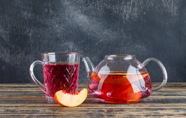 Nectarine with cold drink on wooden and grungy wall, side view.