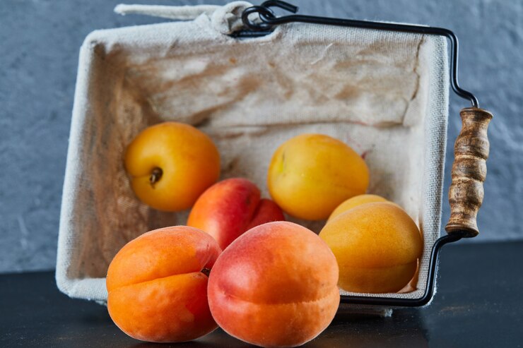 Free Photo nectarines and apricots in basket on blue surface