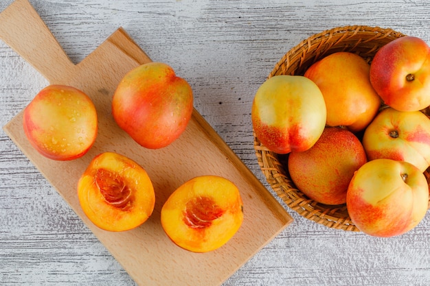 Nectarines in a basket on grungy and cutting board table. flat lay.