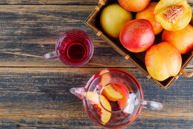 Nectarines in a basket with cold drink top view on a wooden table