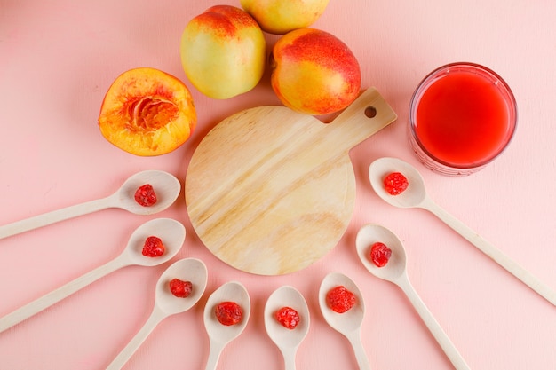 Nectarines with juice, dried cherry flat lay on pink and cutting board table