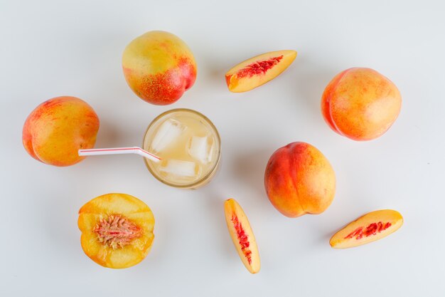 Nectarines with juice top view on a white table