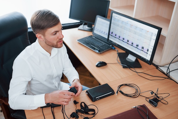 Free photo need some things to be done before we started. polygraph examiner works in the office with his lie detector's equipment