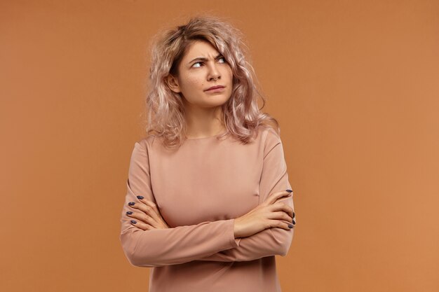 Negative human emotions, attitude and reaction. Displeased angry European girl wearing facial piercing expressing dissatisfaction, being offended