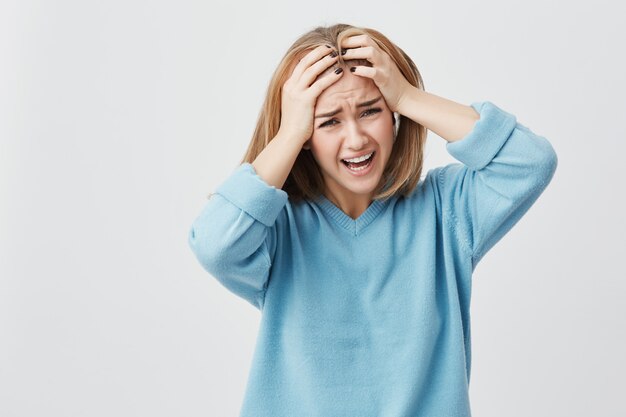 Negative human emotions, reaction and attitude. Frustrated annoyed and angry student girl covering ears with hands, feeling irritated with loud annoying noise, can't concentrate on study