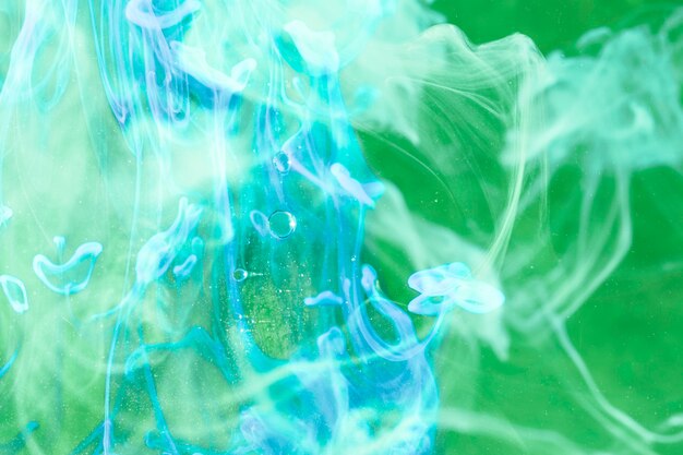 緑色の画面上のネオンブルーの煙
