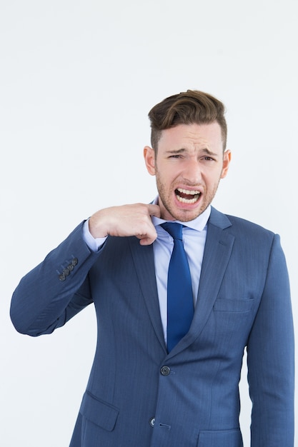 Nervous businessman crying and tearing away tie