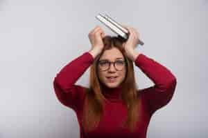 Free photo nervous female student with books over head