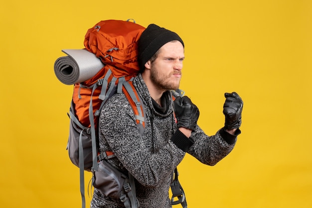 nervous male hitchhiker with leather gloves and backpack being ready to fight