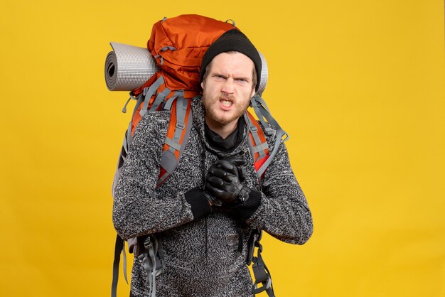 Free photo nervous male hitchhiker with leather gloves and backpack showing punches