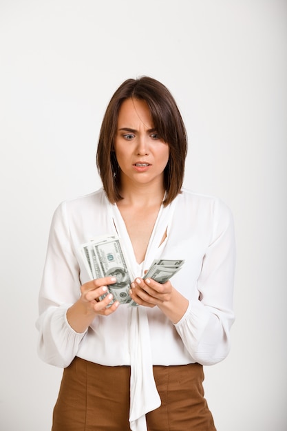 Бесплатное фото Нервная женщина считает деньги обеспокоены