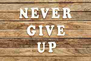 Free photo never give up words made of wooden letters on a wooden background