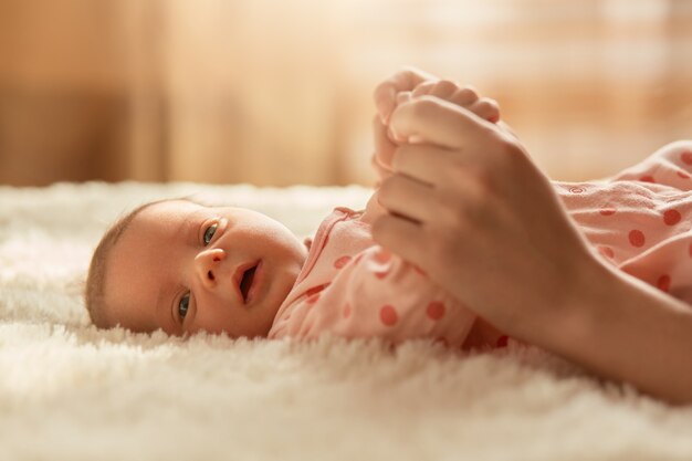 白いベッドの上で赤ちゃんの足を新生児 無料の写真