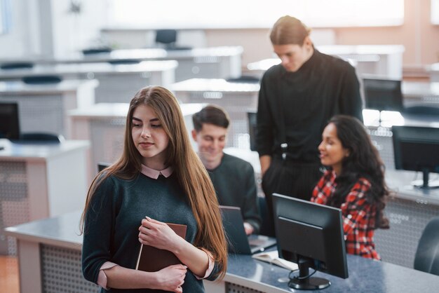 New day has come. Group of young people in casual clothes working in the modern office