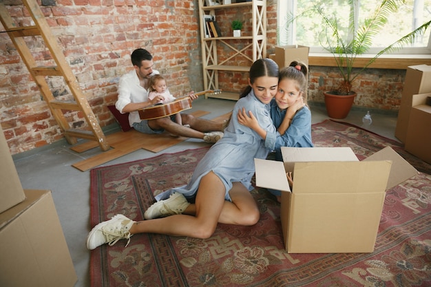 New life. Adult family moved to a new house or apartment. Spouses and children look happy and confident