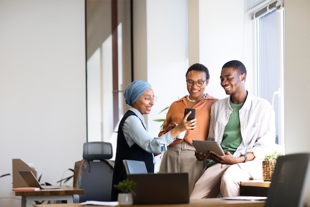 New male employee conversing with female colleagues at his new office job