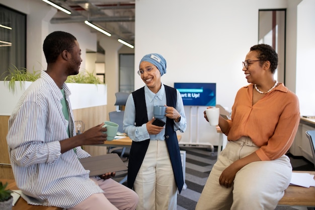 New male employee conversing with female colleagues at his new office job