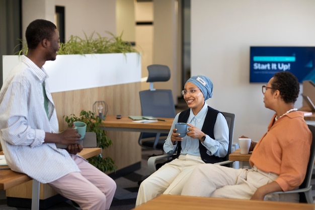 New male employee conversing with female colleagues at his new office job