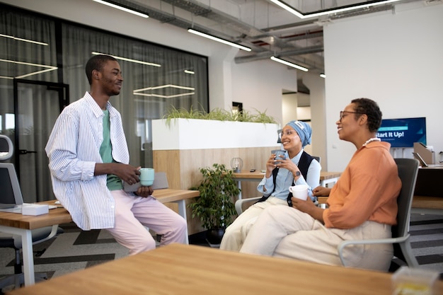 New male employee conversing with female colleagues at his new office job