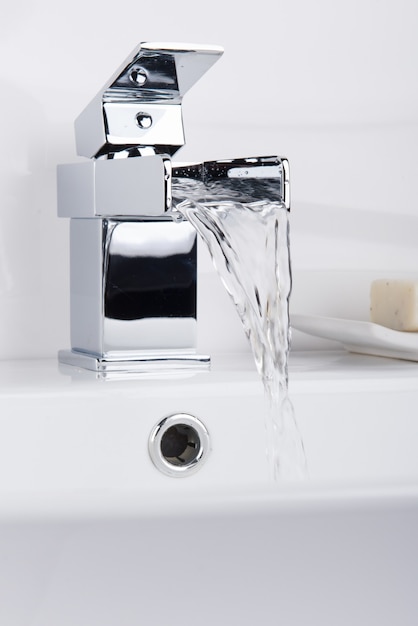 Foto gratuita nuovo e moderno rubinetto in acciaio con lavabo in ceramica in bagno