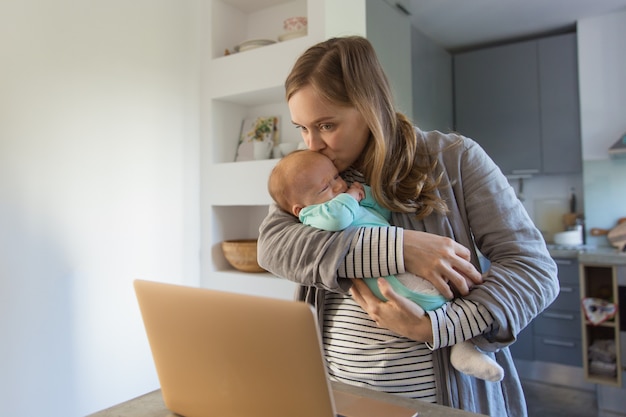 Foto gratuita film di sorveglianza della nuova madre sul computer portatile