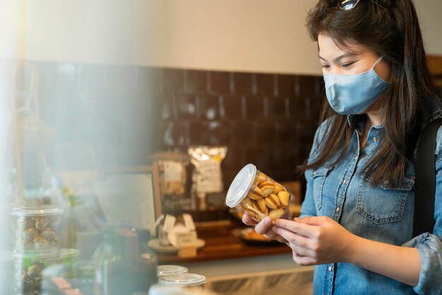 New normal lifestyle asian female blue shirt wear protecting mask shopping in department store after end of lockdown quarantine period