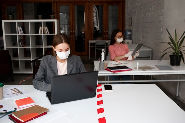 Foto gratuita nuovo normale in ufficio con maschera facciale