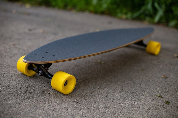 Free photo new wooden penny board with yellow wheels on the asphalt