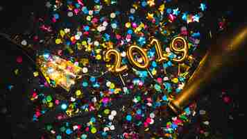 Free photo new year 2019 shaped candles on confetti stack