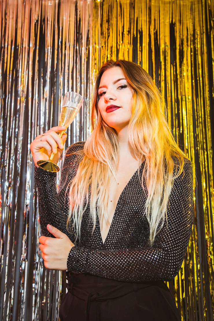 Free Photo new year celebration concept with elegant woman holding glass