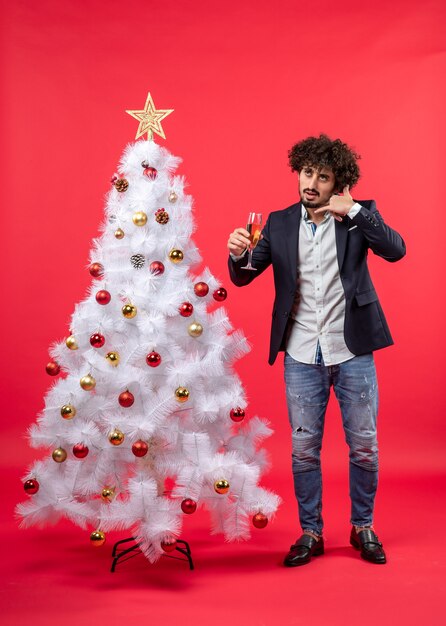 New year celebration with bearded young man holding a glass of wine making call me gesture