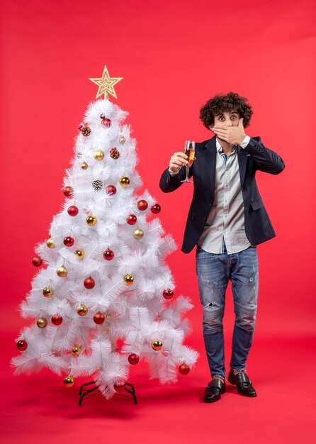 New year celebration with young man holding a glass of wine closing his mouth