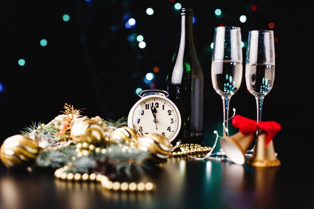 New Year and Christmas decor. Glasses for champagne, clock and toys for Christmas tree 
