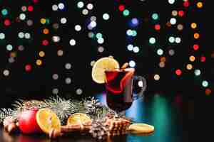 Foto gratuita capodanno e decorazioni natalizie. gli occhiali con vin brulè stanno sul tavolo con le arance, le mele