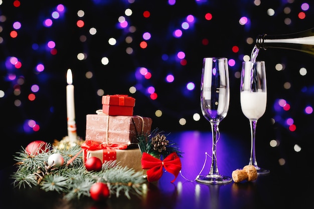 新年とクリスマスの装飾。誰かがグラスにシャンパンを注ぐ
