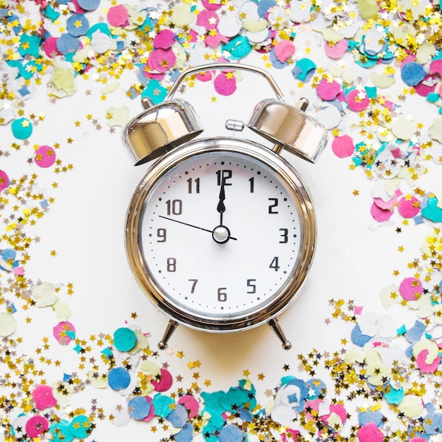 Free photo new year composition with alarm and confetti