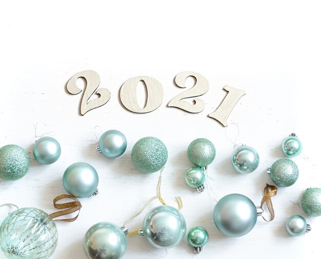 Новогодняя композиция с деревянным номером на наступающий год и синими елочными шарами.