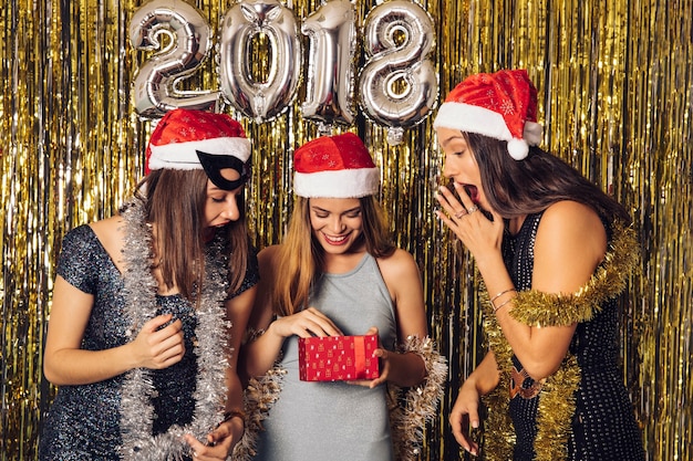 Free photo new year concept with girls receiving gift